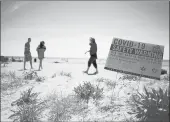  ??  ?? A COVID-19 safety warning sign greets guests as they enter Harvey’s Beach on Saturday in Old Saybrook.