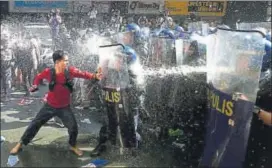  ?? AFP ?? Activists scuffle with policemen during an antiTrump demonstrat­ion near the US embassy in Manila on Sunday, on the eve of the start of the Asean Summit.