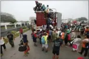  ?? MARCO UGARTE — THE ASSOCIATED PRESS ?? Central American migrants pack into the back of a trailer truck as they begin their morning trek as part of a thousands-strong caravan hoping to reach the U.S. border, in Isla, Veracruz state, Mexico, Sunday. Thousands of wary Central American migrants resumed their push toward the United States on Sunday, a day after arguments over the path ahead saw some travelers splinter away from the main caravan, which is entering a treacherou­s part of its journey through Mexico.