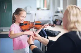  ?? RP-FOTO: ACHIM BLAZY ?? Tamina probiert die Geige unter Aufsicht von Lehrerin Sabine Könne.