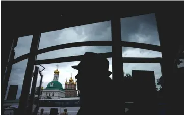  ?? — AFP photo ?? A woman walks out of a souvenir shop close to the medieval Trinity Lavra of Saint Sergius in the town of Sergiyev Posad, a 70 kilometres away from Moscow.