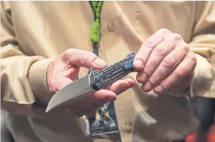  ?? BRIDGET BENNETT THE WASHINGTON POST ?? Todd Rathner, director of legislativ­e affairs for Knife Rights, holds a one-handed open knife.