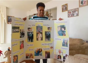  ??  ?? Dorothy Reeves, 79, holds a board designed to help her husband, Levi, who has Lewy body dementia, remember their family members.