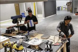  ?? BRENDAN BANNON / NEW YORK TIMES ?? David Natarelli, chief technology officer at obvus Solutions, works on laptop stands with his wife, Shiela, at the company’s factory in Victor, N.Y. Small businesses are shifting to domestic sourcing and taking advantage of their flexibilit­y.