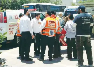  ?? (United Hatzalah) ?? AMBULANCE STAFF in Ashdod attend the scene on May 30 where an infant left in a car died of heat prostratio­n.