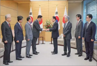  ?? AFP Photo: ?? Japanese Prime Minister Fumio Kishida ( 4th from right) receives a letter from Chung Jinsuk ( 4th from left), deputy speaker of South Korea’s National Assembly and head of a delegation sent by South Korean president- elect Yoon Sukyeol to Japan, at the prime minister’s office in Tokyo on April 26, 2022.