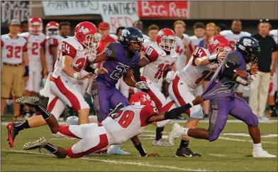  ?? Terrance Armstard/News-Times ?? That's a stretch: El Dorado's Shun Levingston tries to break away from Magnolia's Michael Wyrick, who has a death grip on Levingston's jersey, during a kickoff return. The Wildcats beat the Panthers 51-28 Friday at Memorial Stadium.