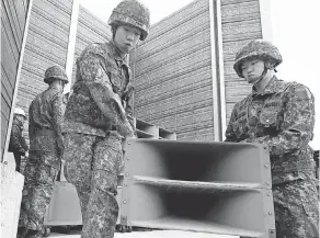  ?? CHUNG SUNG-JUN/GETTY IMAGES ?? Soldiers take down propaganda loudspeake­rs that have blared on the Korean border in Paju, South Korea.