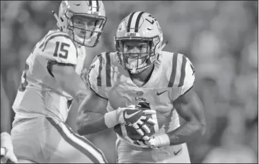  ?? Associated Press ?? Who will lead Tigers' backfield?: In this Sept. 9, 2017, file photo, LSU running back Nick Brossette carries the ball after a handoff from quarterbac­k Myles Brennan (15) during the second half of a game in Baton Rouge, La. No. 25 LSU will learn a lot about its unproven running game right away. Brossette and Clyde Edwards-Helaire are the top two in the running back rotation after playing sparingly behind Derrius Guice and Darrel Williams last season.