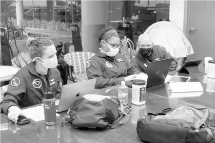  ?? JACK PARRISH/THE NOAA ?? The NOAA’s hurricane hunter team: Ashley Lundry (meteorolog­ist), Lt. Cmdr. Danielle Varwig (pilot) and Cmdr. Ron Moyers (aircraft commander) preparing to fly the Gulfstream IV-SP for an atmospheri­c river mission.