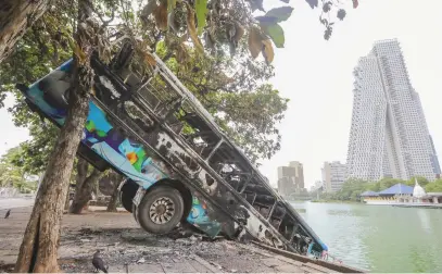  ?? Picture: EPA-EFE ?? OVER THE EDGE. A bus torched during political unrest hangs off a promenade during an island-wide curfew in Colombo, Sri Lanka, yesterday.