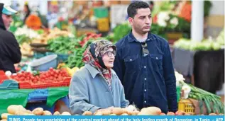  ?? ?? TUNIS: People buy vegetables at the central market ahead of the holy fasting month of Ramadan, in Tunis. – AFP