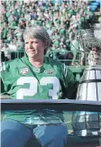  ??  ?? Ron Lancaster’s daughter Lana Mueller with the Grey Cup in Mosaic Stadium on Saturday.