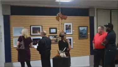  ?? KEITH REYNOLDS — THE MORNING JOURNAL ?? Art fans examine the pieces in the Focused art show during the opening reception Oct. 28 at the Lorain Arts Council, 737 Broadway Ave.