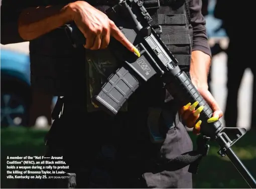  ?? JEFF DEAN/GETTY ?? A member of the “Not F——- Around Coalition” (NFAC), an all Black militia, holds a weapon during a rally to protest the killing of Breonna Taylor, in Louisville, Kentucky on July 25.