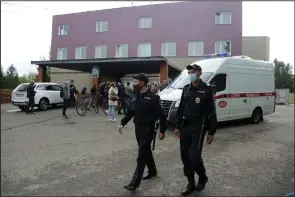  ?? (AP/Evgeniy Sofiychuk) ?? Police patrol as journalist­s gather Friday at the hospital in Omsk, Russia, where opposition activist Alexei Navalny was being treated.