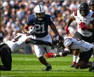  ?? BARRY REEGER — THE ASSOCIATED PRESS ?? Penn State running back Noah Cain splits two Ball State defenders on a first half run in State College, Pa., on Sept. 11. Penn State defeated Ball State 44-13.