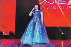  ??  ?? Top: Wang Yiwen (middle), holding a birthday cake, performs a musical called Happy Birthday with her classmates. Above: Wang gives a performanc­e at Zhejiang University in Hangzhou in 2019.