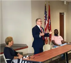  ?? (Pine Bluff Commercial/Byron Tate) ?? Robert Jones (center) a finalist for the Pine Bluff police chief position, tells a group of business leaders Tuesday that the city has a gang problem that will require outside help to control, as Mayor Shirley Washington and Paul George, who works for Jones, look on.