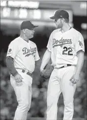  ??  ?? MANAGER Dave Roberts, left, visits Clayton Kershaw, who passed Sandy Koufax in career strikeouts.