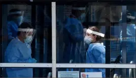  ?? Olivier Douliery/AFP via Getty Images ?? Health care workers wait for patients to be tested May 12 at a walk-in COVID-19 testing site in Arlington, Va.