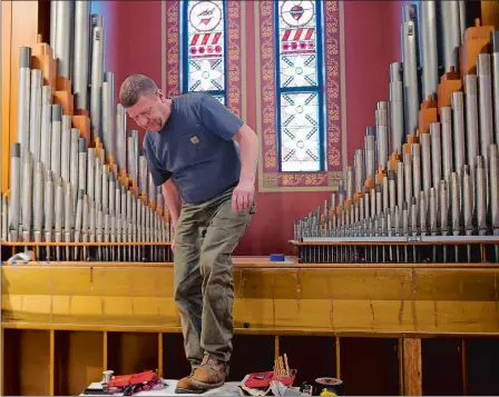  ?? SARAH GORDON/THE DAY ?? Amory Atkins, with The Organ Clearing House out of Boston, works on setting organ pipes Wednesday at St. Michael Church in Pawcatuck. The instrument, original to the church, had to be taken apart and reconstruc­ted, including its more than 1,000 pipes. The church is reopening on Saturday morning with a Mass and celebratio­n following a major reconstruc­tion project after closing due to structural problems in 2012.