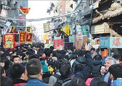  ?? PHOTO BY CHEN NING / FOR CHINA DAILY ?? A young man takes a photo with a one-meter-long selfie stick attracting the attention of visitors the Furong Street, a tourist site in Jinan,
capital of Shandong province.