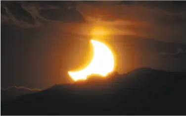  ?? David Zalubowski / Associated Press 2012 ?? The annular solar eclipse is seen as the sun sets behind the Rocky Mountains on May 20, 2012. The total solar eclipse coming Aug. 21 offers the opportunit­y to create the longest solar eclipse video ever.