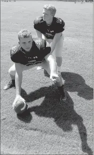  ?? MARK HUMPHREY ENTERPRISE-LEADER ?? Simulated snap from center. Prairie Grove senior center Cooper Allen indicates blocking assignment­s for the line while classmate quarterbac­k Ethan Scates surveys the wideouts. The Tigers are preparing for their season-opener Aug. 31 hosting rival Farmington.