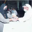  ??  ?? A staff puts tracking bracelet on a passenger at the Muscat Internatio­nal Airport on Sunday.