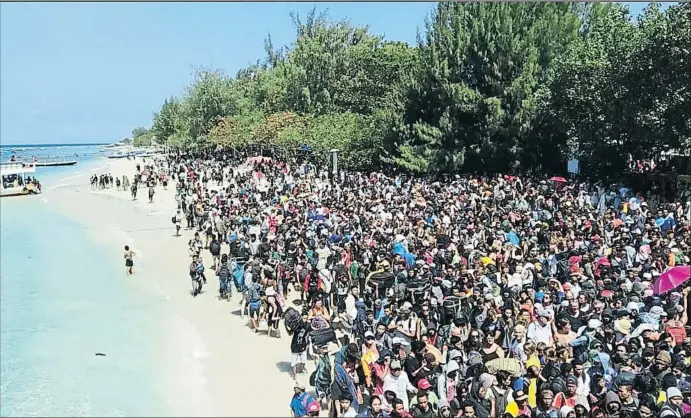  ?? AKBP. DEWA WIJAYA / AP ?? Cientos de turistas y habitantes del islote de Gili Trawangan concentrad­os ayer en la playa en espera de ser evacuados hacia la isla de Lombok