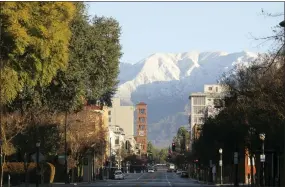  ?? JOHN ANTCZAK — THE ASSOCIATED PRESS ?? Snow glistens on mountain peaks above Pasadena, Calif., on Sunday after a major winter storm swept the state. Snow fell to unusually low elevations in Southern California.