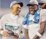  ?? Tim Nwachukwu / Getty Images ?? Eagles quarterbac­k Jalen Hurts, left, holds the George Halas Trophy after defeating the 49ers in the NFC Championsh­ip game on Sunday.