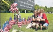  ?? Joe Raedle Getty Images ?? MOURNERS pay respects at a memorial to the service members at the reserve center in Chattanoog­a.