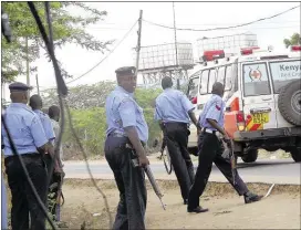  ?? ASSOCIATED PRESS ?? Kenyan police officers take positions outside Garissa University College as an ambulance took victims to a hospital on Thursday. Al-Shabab militants attacked the university early Thursday, shooting indiscrimi­nately in campus hostels. Police and...