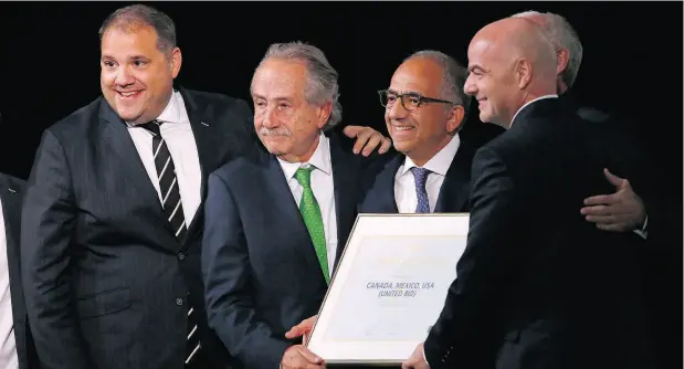  ?? ALEXANDER ZEMLIANICH­ENKO / THE ASSOCIATED PRESS ?? Delegates of Canada, Mexico and the United States celebrate with FIFA President Gianni Infantino, right, after winning a joint bid to host the 2026 World Cup at the FIFA congress in Moscow earlier this month. At left is Victor Montaglian­i, the...