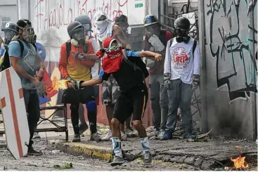  ?? Fernando Llano / Associated Press ?? Anti-government protesters in Caracas, Venezuela, clashed with security forces Saturday during a march to the Supreme Court in opposition of President Nicolas Maduro’s plan to rewrite the constituti­on.