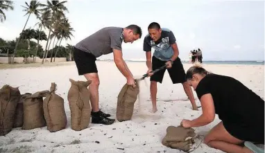  ?? PICTURE: AP ?? RESIDENTS SCRAMBLE: People fill up sand bags on Ewa Beach in Honolulu on Wednesday. They took the sand bags to their homes to protect them from Hurricane Lane, which was scheduled to move across Hawaii yesterday.