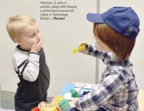  ?? — Reuters ?? Harrison, 5, who is autistic, plays with Kaspar, a child-sized humanoid robot in Stevenage, Britain.