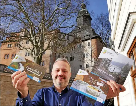  ?? ?? Matthias Deichstett­er zeigt ein Kloßrezept aus Sondershau­sen, Gutscheinh­eft sowie eine Broschüre über die Region Nordthürin­gen. Damit will man bei der Grünen Woche in Berlin für die Region werben.
CHRISTOPH VOGEL (2)