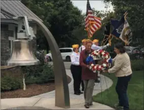  ?? PHOTOS BY PAUL POST — PPOST@DIGITALFIR­STMEDIA.COM ?? Sisters Donna Wells and Cindy Allwall place a wreath Friday during ceremonies honoring sailors who served aboard the USS Emmons in World War II. Their father, Warren G. Sparks, is one of four shipmates who passed away in the past year.