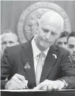  ?? SCOTT KEELER, TNS ?? Gov. Rick Scott signs into law gun and school safety legislatio­n in Tallahasse­e, Florida, on Friday.