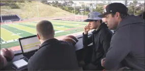  ?? Associated Press ?? Wilson Labs engineer Dan Hare, left, explains to Sam Darnold, center, and his mentor and former quarterbac­k Jordan Palmer data gathered from throwing a football using the Wilson Connected Football System, at San Clemente High School.