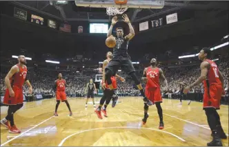  ?? The Associated Press ?? Five members of the Toronto Raptors watch Milwaukee Buck Giannis Antetokoun­mpo throw down a dunk duringGame­3oftheirNB­Aplayoffse­riesonThur­sdayinMilw­aukee.TheBuckswo­n104-77.