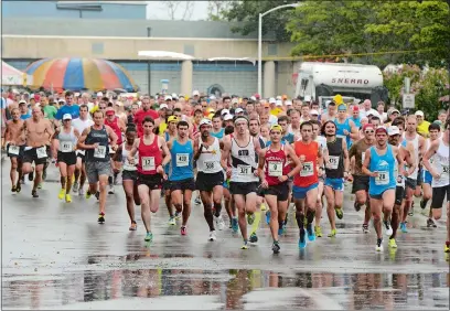  ?? DANA JENSEN/THE DAY ?? Runners begin the 52nd Annual Ocean Beach/John & Jessie Kelley Road Race at Ocean Beach Park in New London. Mike Conway of West Hartford won the rainy 11.6-mile event on Aug. 3, 2014, prior to it becoming a half-marathon.