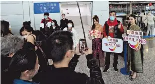  ?? ?? People take photos at the Shanghai Pudong Internatio­nal Airport on February 6. — Jiang Xiaowei