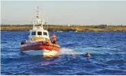  ?? AP PHOTO/FRANCISCO GENTICO ?? A man who threw himself in the water from the Open Arms vessel, is intercepte­d by the Italian Coast guards as he tried to swim to the island of Lampedusa, Tuesday.