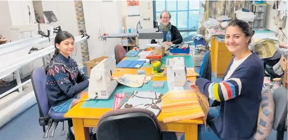  ?? Photo / Supplied ?? Florence Patel-Gaunt, 13, and Claudia Patel-Gaunt, 14, front, are joined by Marg Wallace to sew together pencil cases and book bags for the Project Pencil Case.