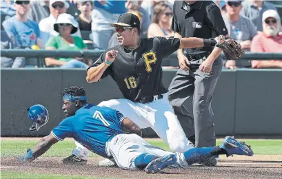  ?? CHRIS O'MEARA THE ASSOCIATED PRESS ?? Toronto’s JD Davis slides safely into third base as the ball skips away from Pittsburgh’s Jung Ho Kang on Friday in Bradenton, Fla.