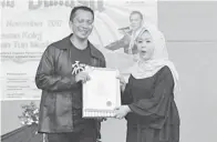  ??  ?? DR Muhamad Nizam menyampaik­an cenderamat­a kepada Dayangku Siti Afizah.